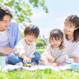 公園でくつろぐ子育て世帯の家族のイメージ